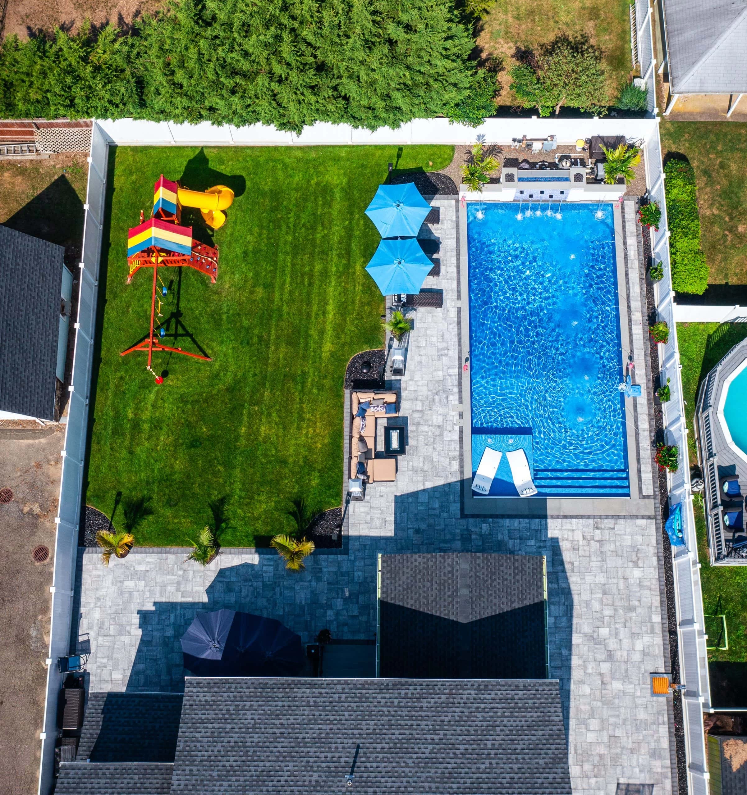 An aerial view of a backyard with a pool and a lawn.