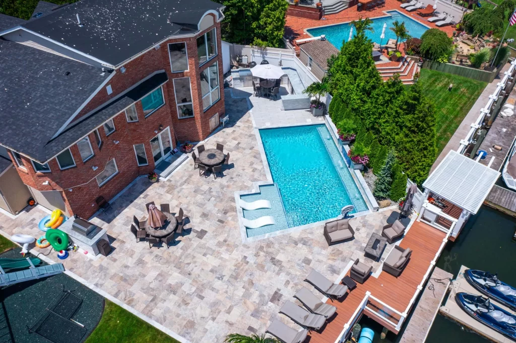 An aerial view of a house with a pool and a dock.