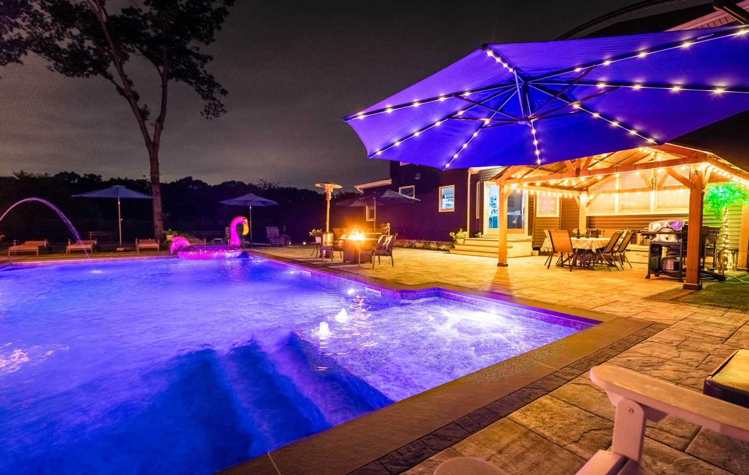inground pool in yard at night.