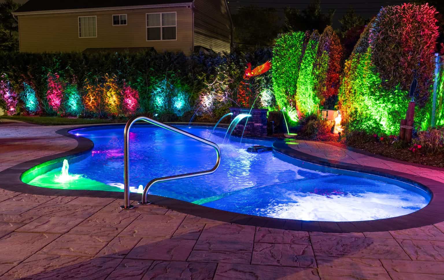custom pool in yard at nighttime.